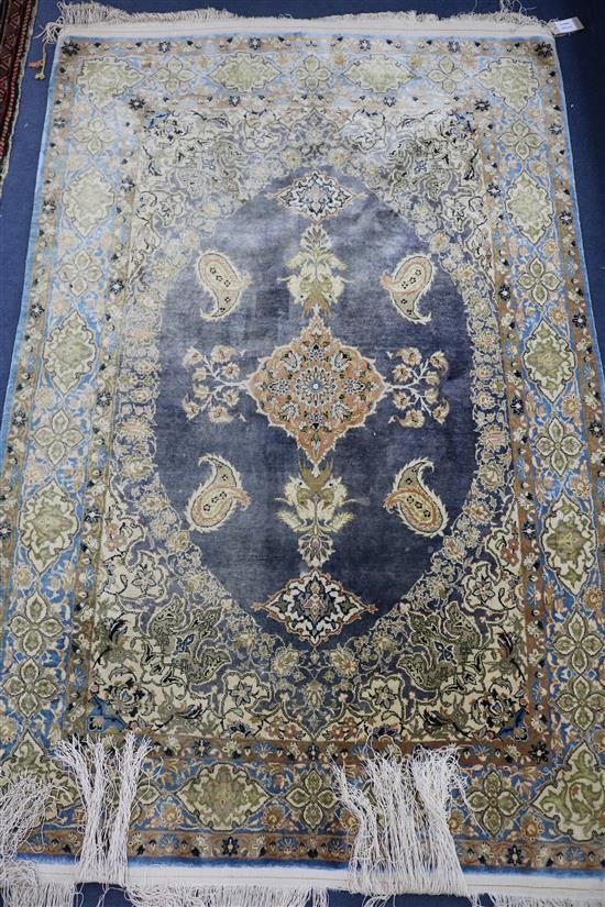 A Persian silk blue ground rug with oval medallion centre, 160cm x 165cm